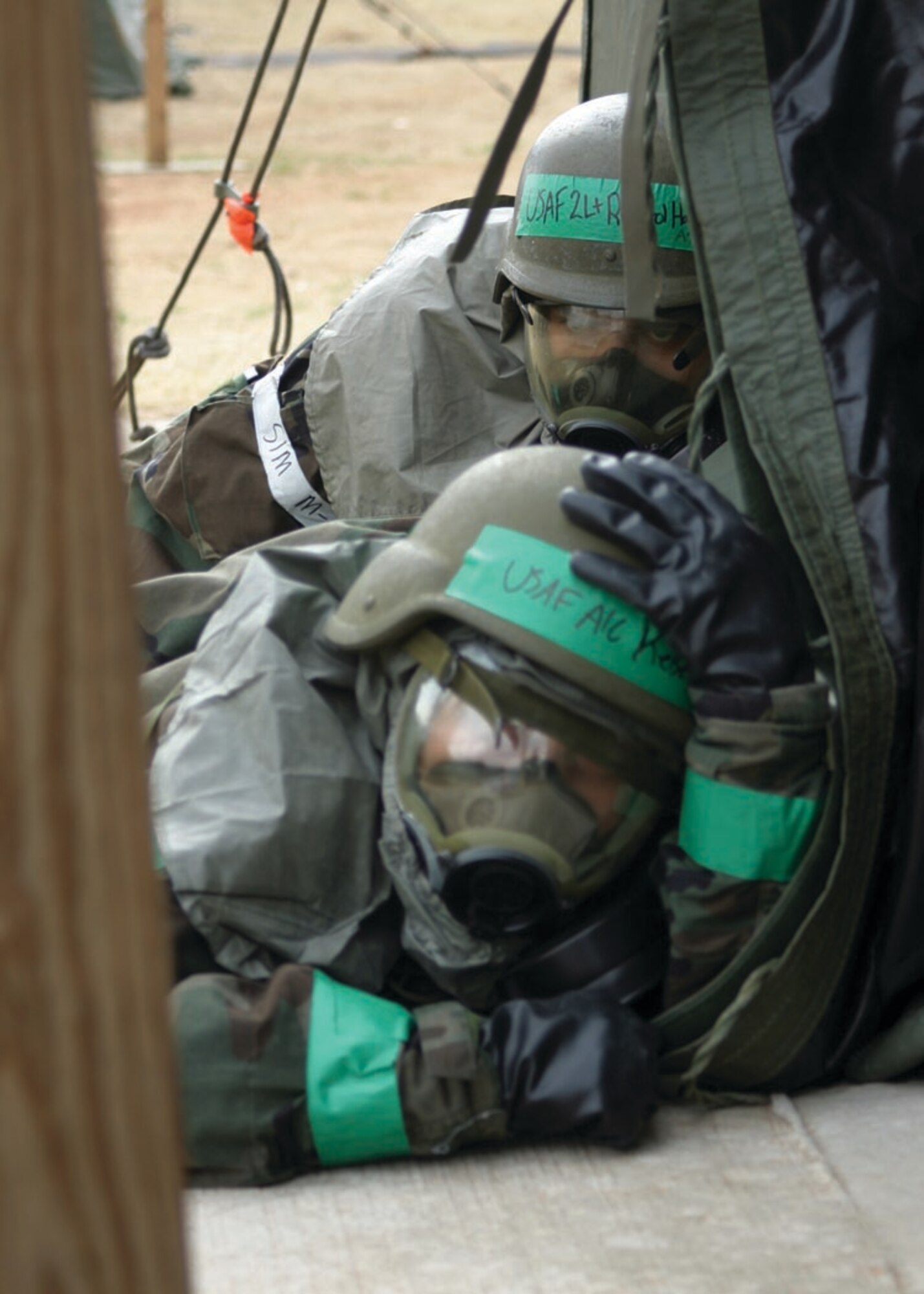 Two Airmen try to find cover after being caught in the open during a mortar attack March 28. With Airmen not knowing if the attack was a chemical attack or conventional mortars, everyone put on all their chemical protection gear until the “all clear” sounded. The 72nd Air Base Wing and the 552nd Air Control Wing teamed up for the first time as the 624th Air Expeditionary Wing to take part in War Wagon 06-03, an Operational Readiness Exercise designed to test both wings processes in a joint simulated deployed environment. See story page 12.