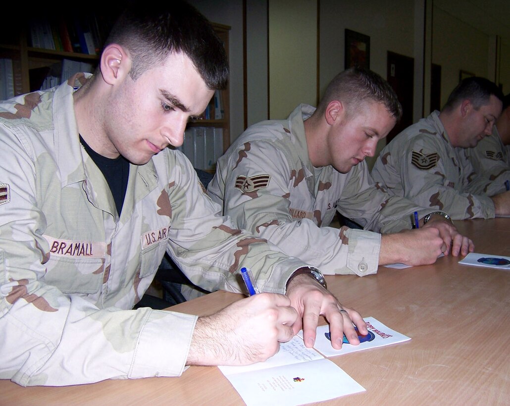 Airman 1st Class David Bramall and Senior Airman Joseph Dillard write letters to Florida school children. Nearly 90 Airmen have joined in the letter-writing campaign to spread the holiday spirit by corresponding with students who wrote to them during the holiday season.  Airmen Bramall and Dillard are deployed with the 379th Expeditionary Civil Engineer Squadron in Southwest Asia. (U.S. Air Force photo/Tech. Sgt. Steve Staedler) 
