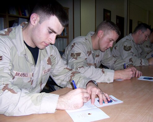 Airman 1st Class David Bramall and Senior Airman Joseph Dillard write letters to Florida school children. Nearly 90 Airmen have joined in the letter-writing campaign to spread the holiday spirit by corresponding with students who wrote to them during the holiday season.  Airmen Bramall and Dillard are deployed with the 379th Expeditionary Civil Engineer Squadron in Southwest Asia. (U.S. Air Force photo/Tech. Sgt. Steve Staedler) 

