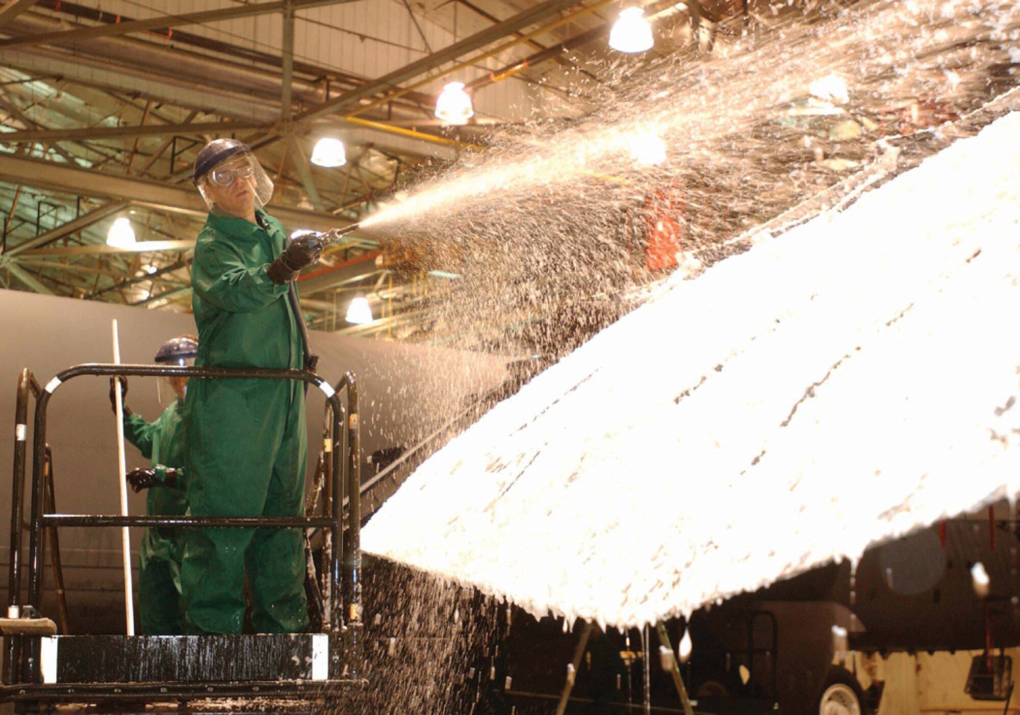 Lt. Col. David Foote, 5th Aircraft Maintenance Squadron commander, washes down one of the wings of a B-52H Stratofortress during an aircraft wash March 31. People could elect their boss or squadron mates to help wash the plane for 25 cents a vote to help raise money for the Air Force Assistance Fund. According to Capt. Randy Schwinler, 5th AMXS, the aircraft takes 111 man hours to wash not including the dry time which can take up to 12 hours given the temperature. The event raised $2,388.