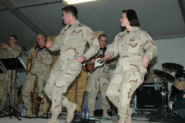 Vocalists Staff Sgt. Craig Bowman and Tech. Sgt. Kimberly Lively step in time to music by the U.S. Air Forces in Europe band Direct Hit during a Dec. 19 performance at Kandahar Airfield, Afghanistan. The band joined USAFE Commander Gen. Tom Hobbins and USAFE Command Chief Master Sgt. Gary Coleman as they journeyed downrange to meet deployed Airmen in Afghanistan.  (U.S. Air Force photo/Master Sgt. Chuck Roberts)