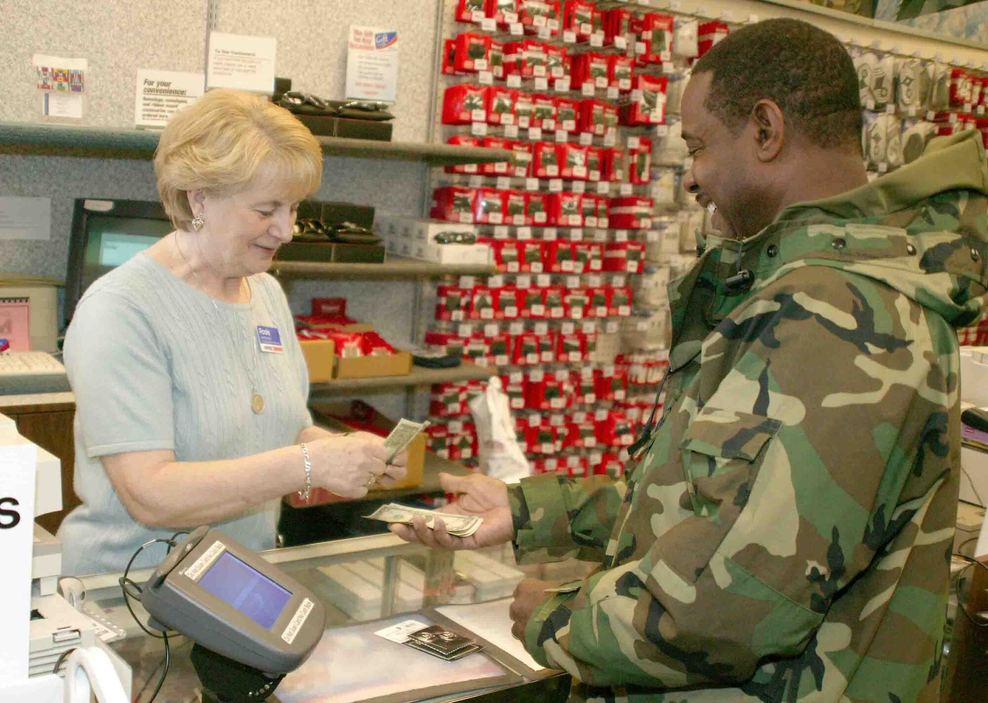 SHAW AIR FORCE BASE, S.C.-- Master Sgt. Timothy Rumph, 20th Security Forces Squadron confinement NCO in charge, purchases new U.S. insignias from Rosie Critchley at the military clothing store Dec. 27. The circled U.S. insignias are mandatory wear for enlisted Airmen starting Jan. 1. (U.S. Air Force photo/Senior Airman John Gordinier)