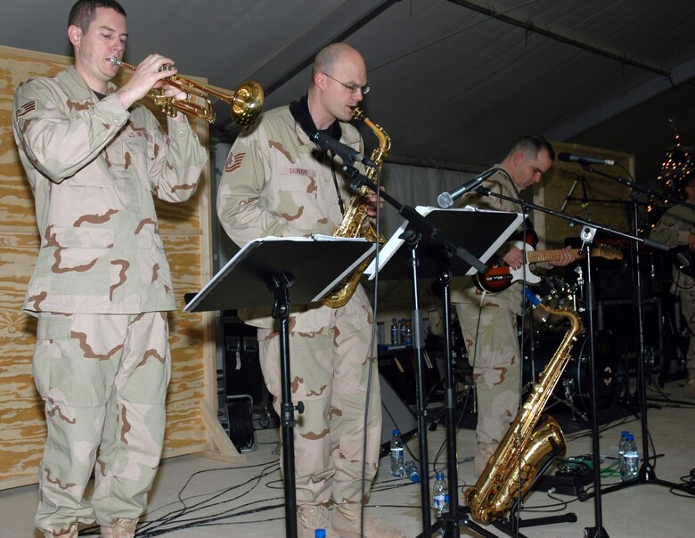 From left, Staff Sgt. Shane Kibbey, Tech. Sgt. Jeffrey Saunders and Senior Airman Ryan Manzi perform Dec. 19 for a combined audience of deployed Airmen and Soldiers as well as servicemembers from England and Holland at Kandahar Airfield in Afghanistan. The band joined USAFE Commander Gen. Tom Hobbins and USAFE Command Chief Master Sgt. Gary Coleman as they journeyed downrange to meet deployed Airmen in Afghanistan.  (U.S. Air Force photo/Master Sgt. Chuck Roberts) 

