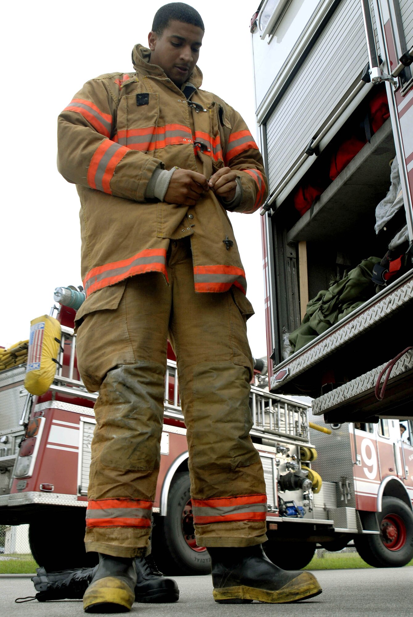 Airman 1st Class Terry Roberts Jr. puts his gear on during a training event at Kadena Air Base, Japan.  Airman Roberts is an 18th Civil Engineer Squadron firefighter and will be on duty during the holiday season. (U.S. Air Force photo/Airman 1st Class Sheila DeVera)