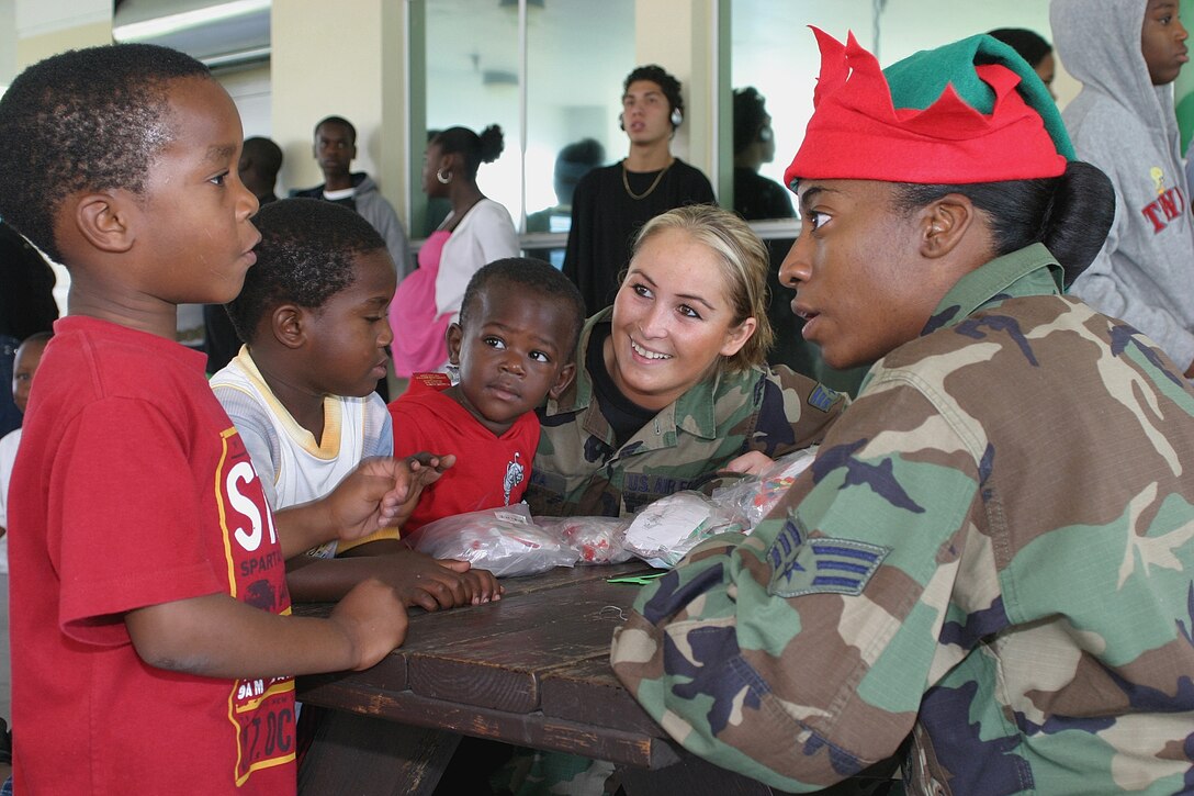 Senior Airmen Tadisha Woods (right) and Karolina Bielecka (center) were two of the many “elves” from the 482nd Medical Squadron who delivered holiday cheer to children at the Community Partnership for Homeless Dec. 3.  The volunteers brought sweets, gifts and crafts to dozens of children and adults at the shelter to brighten their season.  The event was part of a community outreach program sponsored by the Homestead Air Reserve Base Junior Enlisted Council.  (Air Force photo/Tech. Sgt. Paul Dean)