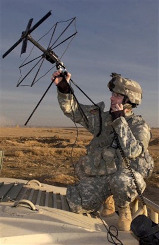 Army Spc. Kerry Lampkin points a satellite communications antenna during an operation to find weapons caches and known terrorist suspects within the village of Malhah in the Kirkuk province of Iraq on Dec. 22, 2006.  Lampkin is from the 35th Infantry Regiment, 25th Infantry Division.  