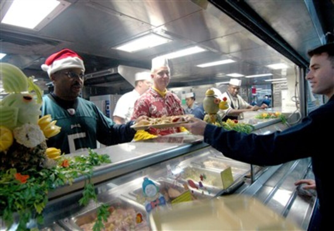 U.S. Navy Capt. Bruce Nichols, commanding officer and Capt. Matthew McCloskey, executive officer, serve Christmas dinner to the crew aboard the amphibious assault ship USS Boxer in the Persian Gulf, Dec. 25, 2006.