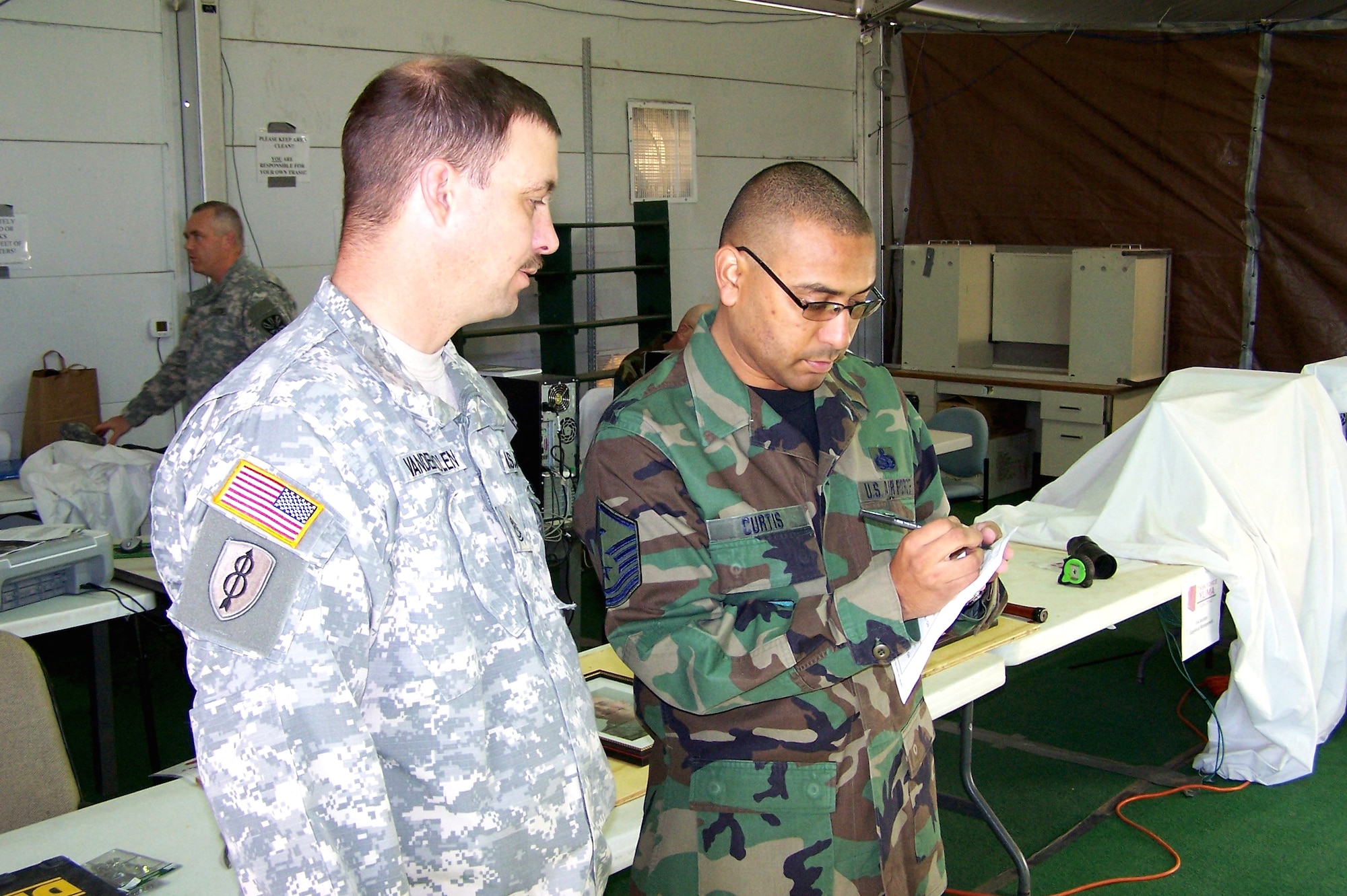 Master Sgt. Greg Curtis makes a note while talking with Sgt. 1st Class Dan Vandermolen. Sergeant Curtis, a member of the Ohio Air National Guard, is currently deployed with Operation Jump Start in Yuma, Ariz. (U.S. Air Force photo/Staff Sgt. Dan Heaton)
