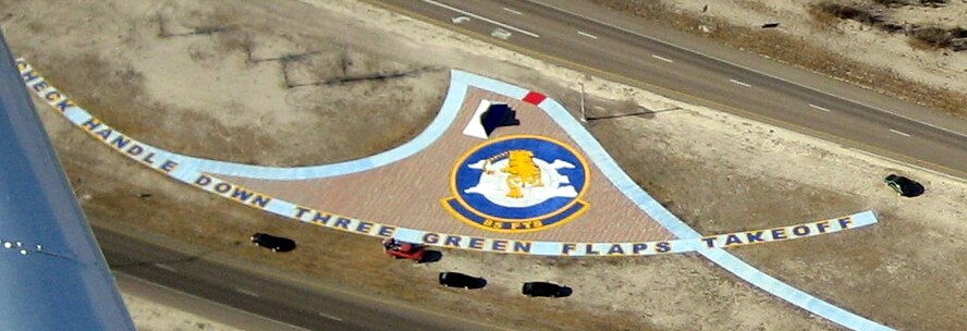 "CHECK HANDLE DOWN THREE GREEN FLAPS TAKEOFF"  
An aerial view from the T-6 Texan II shows the Flying Tigers' squadron patch, which was painted into the brickwork in the median strip of Highway 90, outside Laughlin's main gate.  Members of the 85th Flying Training Squadron spent more than seven hours on the project Dec. 27.  (U.S. Air Force photo by Lt. Col. Paul Beineke)  
