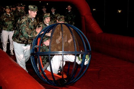 Airman Basic Peter Caruso from the 320th Training Squadron rolls down the human bowling alley, powered by his flight mates, during the Basic Military Training Christmas Eve Extravaganza on Dec. 24 at Lackland Air Force Base, Texas. (USAF photo by Staff Sgt. Tim Russer)