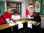 Santa and Mrs. Claus pay a visit to the Defense Language Institute English Language Center at Lackland Air Force Base, Texas, Dec. 21.  DLIELC international military students were surprised when the Clauses appeared in the classroom handing out candy. Before the candy was distributed, the students were asked if they had been good this year. (USAF photo by Annette D. Janetzke)