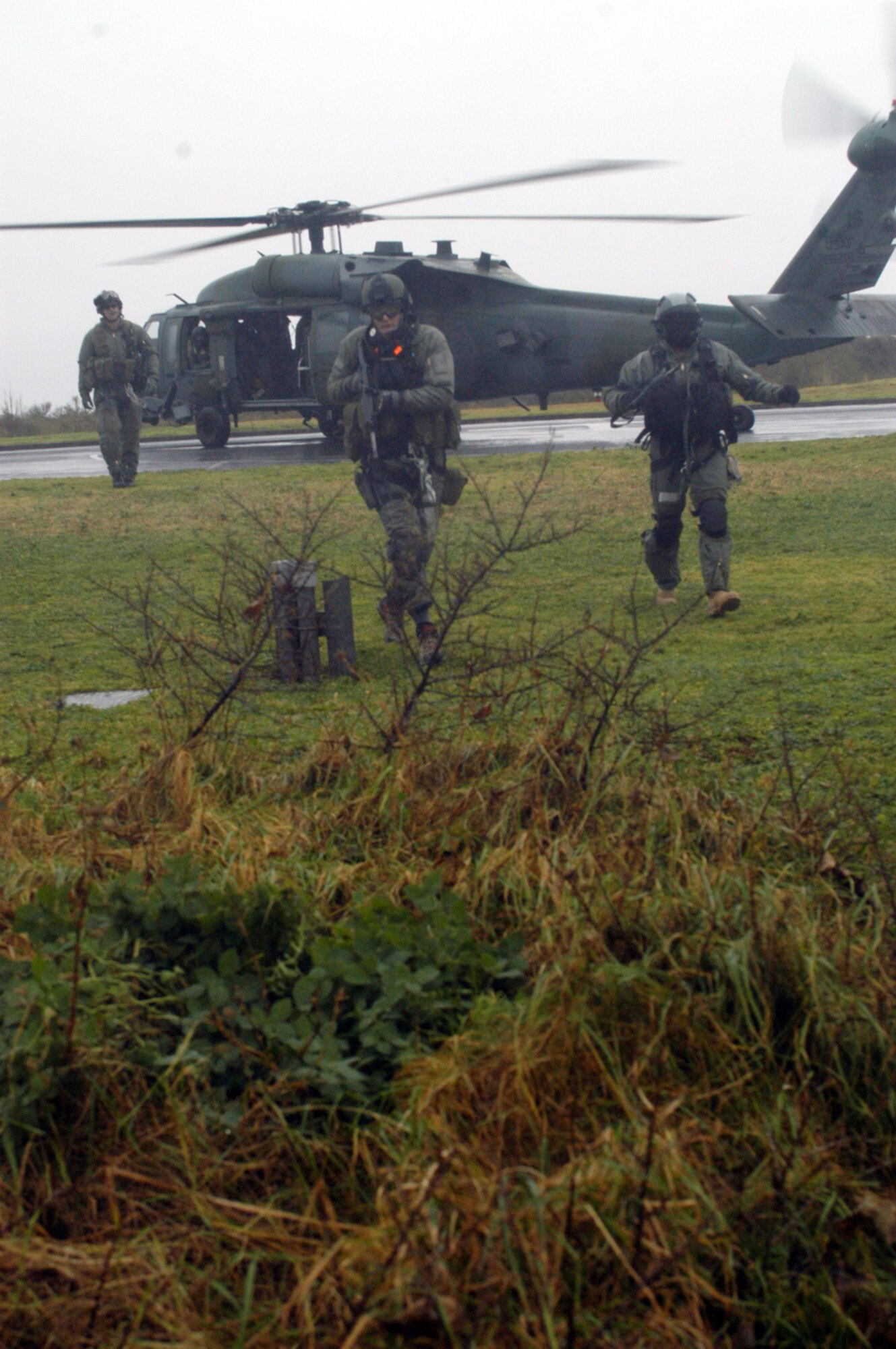 (Left to right) Pararescuers Tech. Sgt. Eric Barry, Tech. Sgt. Michael Gray and Senior Airman Kristofer Abel, 56th Rescue Squadron, run toward the aircrew of a simulated downed F-15E during a large force exercise Dec. 15. (Air Force photo by Airman 1st Class Kris Levasseur)