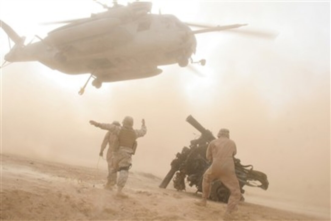 U.S. Marines direct the crew of a CH-53E Super Stallion helicopter as it prepares to pick up a rotor head from a downed CH-53E near Al Qa'im, Iraq, on Dec. 15, 2006.  Marines with Heavy Marine Helicopter Squadron 465 are deployed with I Marine Expeditionary Force in support of Operation Iraqi Freedom.  