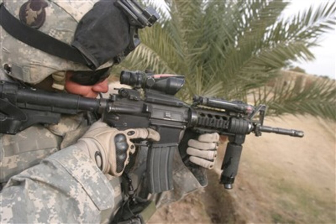 U.S. Army Sgt. Jonathan Goldstein uses the scope on his rifle to survey the surrounding area during an operation in Al Naumyah in the Al Anbar province of Iraq on Dec. 15, 2006.  Goldstein is attached to the Armyís 1st Platoon, Bravo Company, 2nd Battalion, 136th Infantry Regiment.  