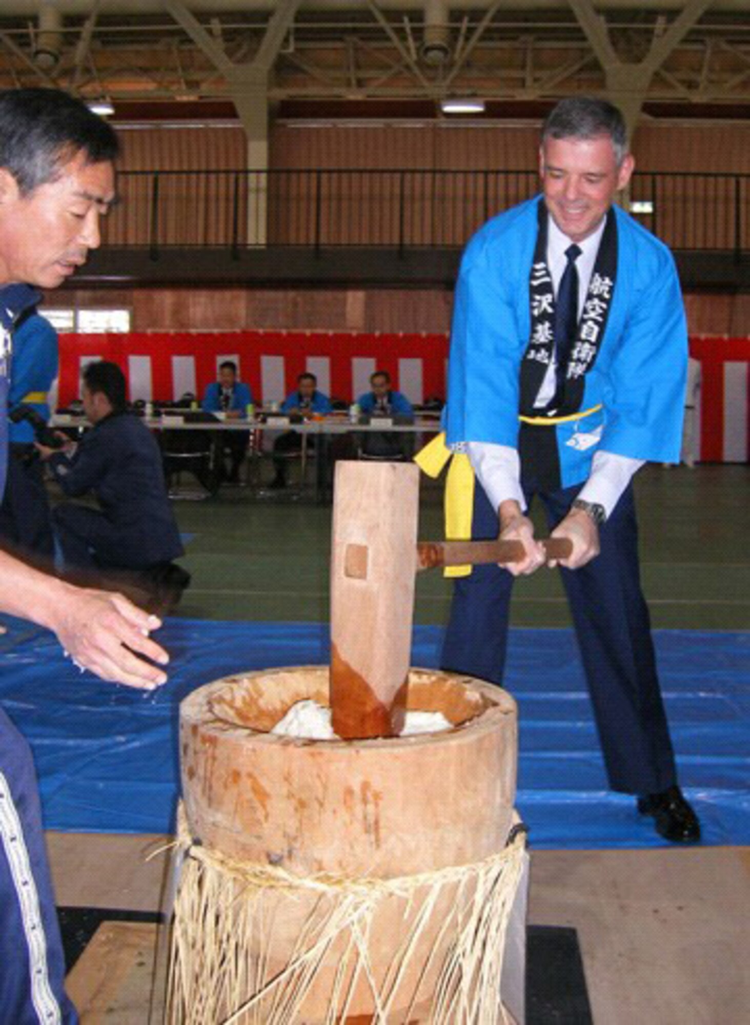 MISAWA AIR Base, Japan -- Brig. Gen. Sam Angelella, 35th Fighter Wing and installation commander, takes part in the annual mochitsuki ceremony Wednesday, Dec. 20. Mochitsuki, or pounding steamed rice, means making mochi (sweet rice cakes). Japanese schedule their mochitsuki events just before the New Year.  It is an event, allowing young and old to socialize and have fun in a community project.