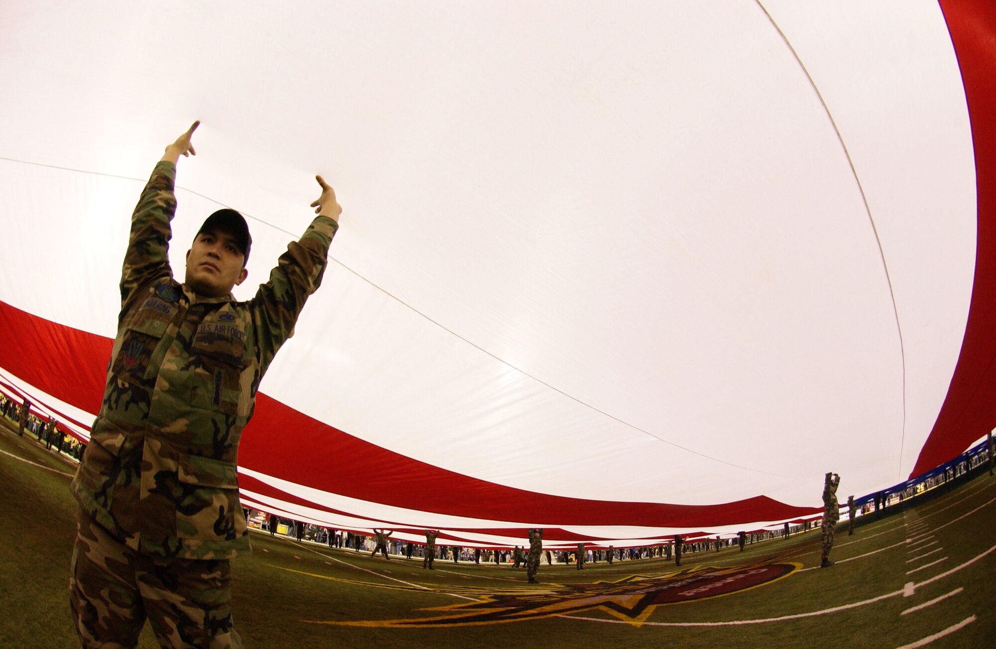 An Airman lifts his section of the 100-yard-by-50 yard American flag. A group of 250 Airmen presented the American flag during the national anthem at the Pioneer PureVision Las Vegas Bowl. The nationally televised football game featured the Brigham Young University Cougars and the University of Oregon Ducks at Sam Boyd Stadium in Las Vegas. The Airmen are from Nellis Air Force Base, Nev. (U.S. Air Force photo/Master Sgt. Kevin J. Gruenwald) 


USAF Photo by: Master. Sgt. Kevin J. Gruenwald
(released)             
