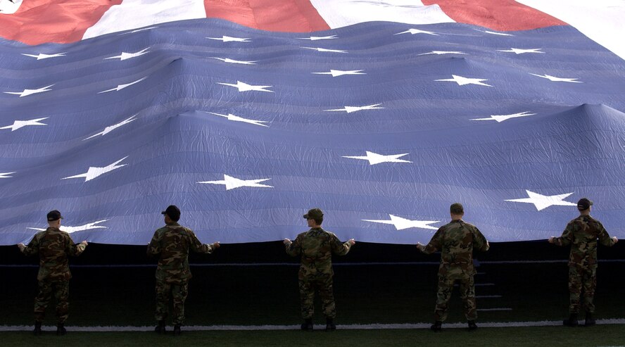 Airmen present the American flag during the national anthem Dec. 21 at the Pioneer PureVision Las Vegas Bowl. The nationally televised football game featured the Brigham Young University Cougars and the University of Oregon Ducks at Sam Boyd Stadium, Las Vegas. The Airmen are from Nellis Air Force Base, Nev. (U.S. Air Force photo/Master Sgt. Kevin J. Gruenwald)USAF Photo by: Master. Sgt. Kevin J. Gruenwald(released)             