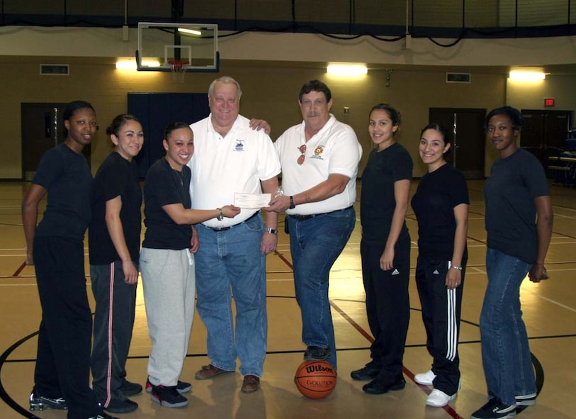 Mr. Terry Benson and Mr. Chip Bar from the Alamogordo chapter of Veterans of Foreign Wars present Staff Sgts. Tanesha Townsend, Marquetta Davalos, Senior Airman Melissa Cordero, Airman Lisette Gaitan, Airman Crystal Romero and Senior Airman Jervette Clark, members of the base girl's basketball team, with a $1,250 check for new uniforms Dec. 7. (U.S. Air Force photo courtesy of Master Sgt. Brian Starr)