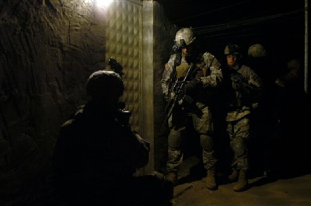 U.S. Army Staff Sgt. Brett Graves (center) and his squad prepare to breach the entrance of a house during an early-morning raid in Siniyah, Iraq, on Dec. 15, 2006.  Graves and his fellow soldiers from Company C, 1st Battalion, 505th Parachute Infantry Regiment, 82nd Airborne Division, are conducting the raid to suppress insurgent activity in the area.  