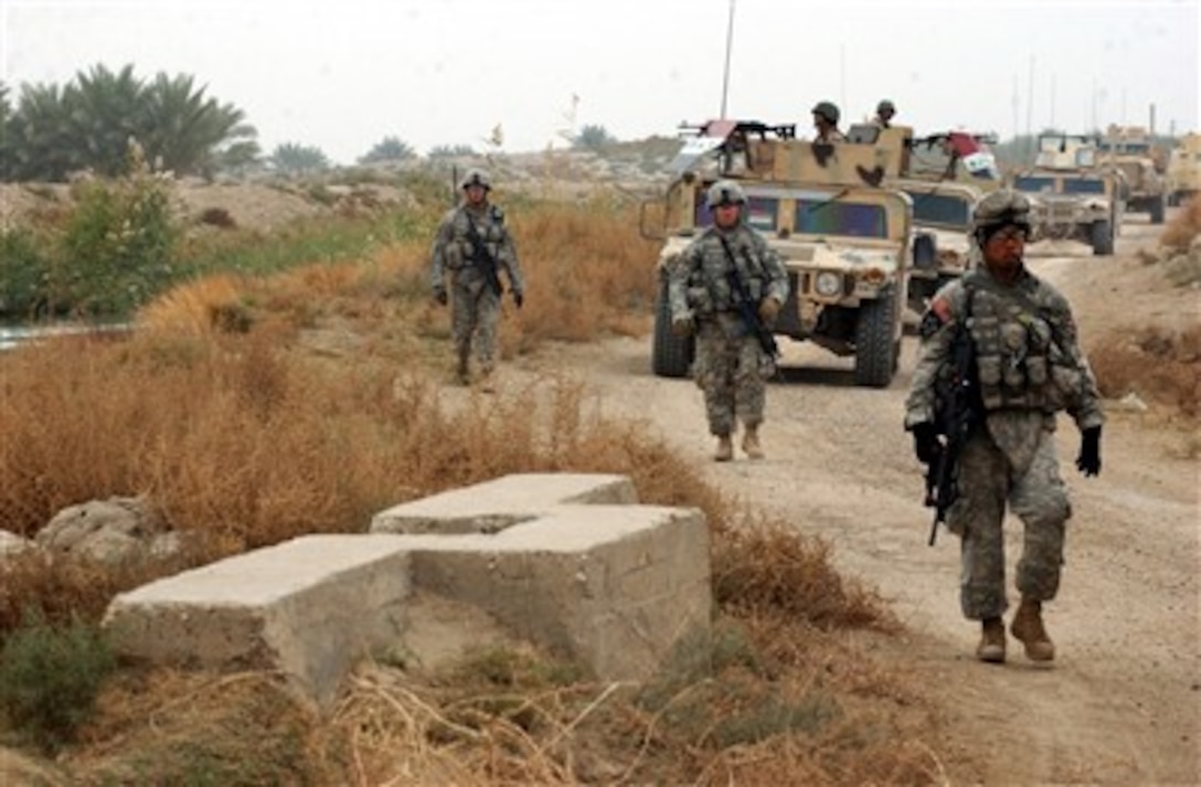 U.S. Army soldiers from the 2nd Battalion, 15th Field Artillery Regiment, 2nd Brigade Combat Team, 10th Mountain Division and Iraqi army soldiers from the 4th Brigade, 6th Iraqi Army Division patrol a rural road near the Shalshabar Canal in Mahmudiyah, Iraq, on Dec. 16, 2006.  The soldiers are patrolling in support of an operation to prevent planning and execution of future improvised explosive devices in Mahmudiyah.  