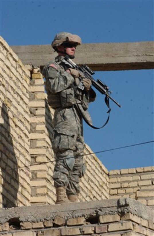 Pfc. Chris Anderson keeps an eye on the street from the second level of an abandoned home in Muqdadiyah, Iraq, on Dec. 18, 2006.  Anderson and his fellow soldiers from Apache Troop, 6th Squadron, 9th Cavalry Regiment, Fort Hood, Texas, and the 5th Iraqi Army Division are conducting joint dismounted patrols in the region to clear abandoned buildings and to suppress insurgent activity.  