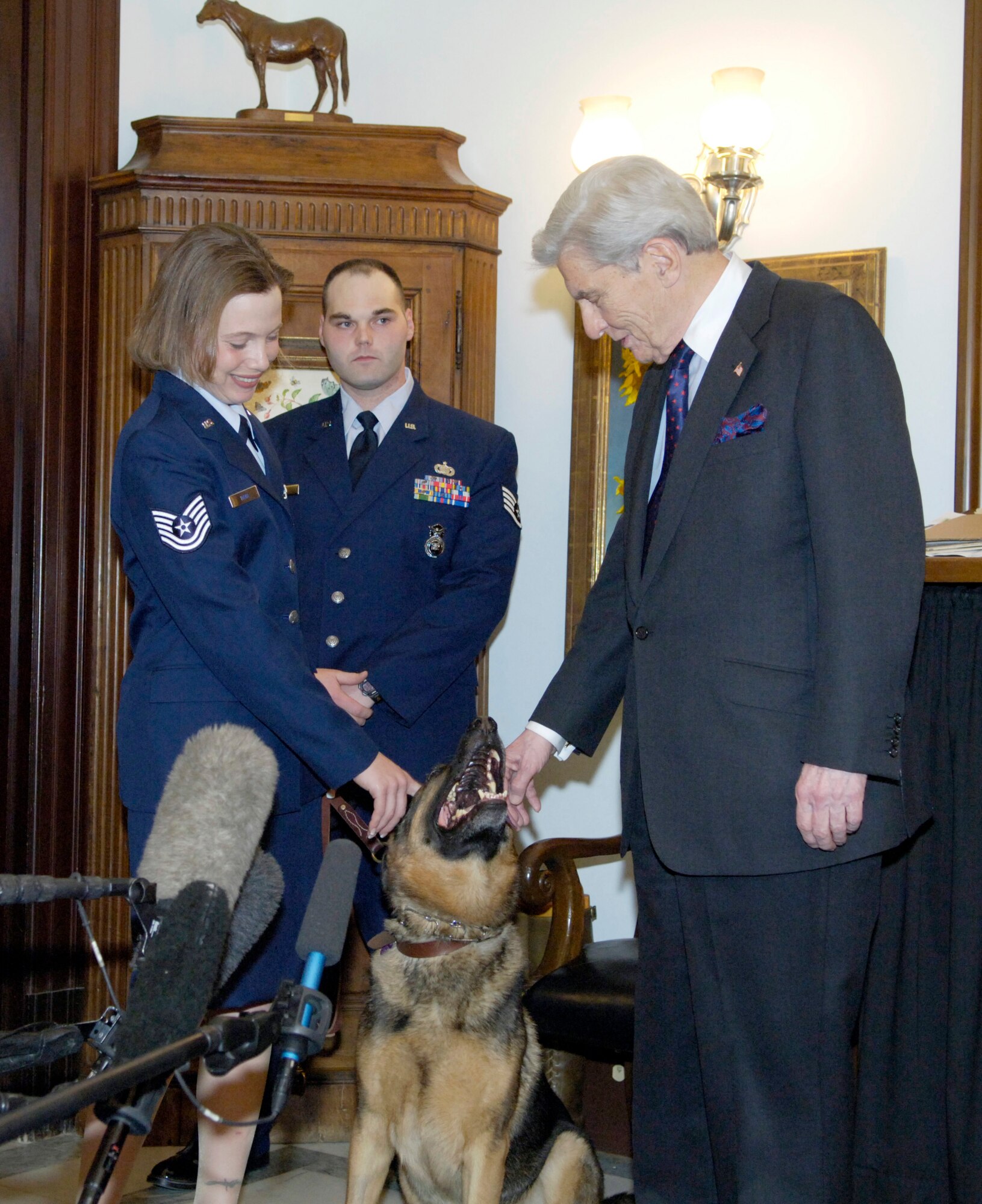 WASHINGTON (AFPN) -- Sen. John Warner, chairman of the Senate Armed Services Committee, meets Rex, a retired military working dog, Tech. Sgt. Jamie Dana, Rex's handler, and Staff Sgt. Michael Dana Jan. 31. Senator Warner was instrumental in pushing through legislation which allowed Sergeant Jamie Dana to adopt Rex following their recovery from injuries they sustained while deployed to Iraq as a military working dog team. Sergeant Jamie Dana, her husband and Rex visited Capitol Hill to thank the members of Congress and Air Force leaders who helped her adopt Rex and to attend President Bush's State of the Union address. The Airmen are both security forces specialists from Peterson Air Force Base, Colo. (U.S. Air Force photo by Master Sgt. Jim Varhegyi) 