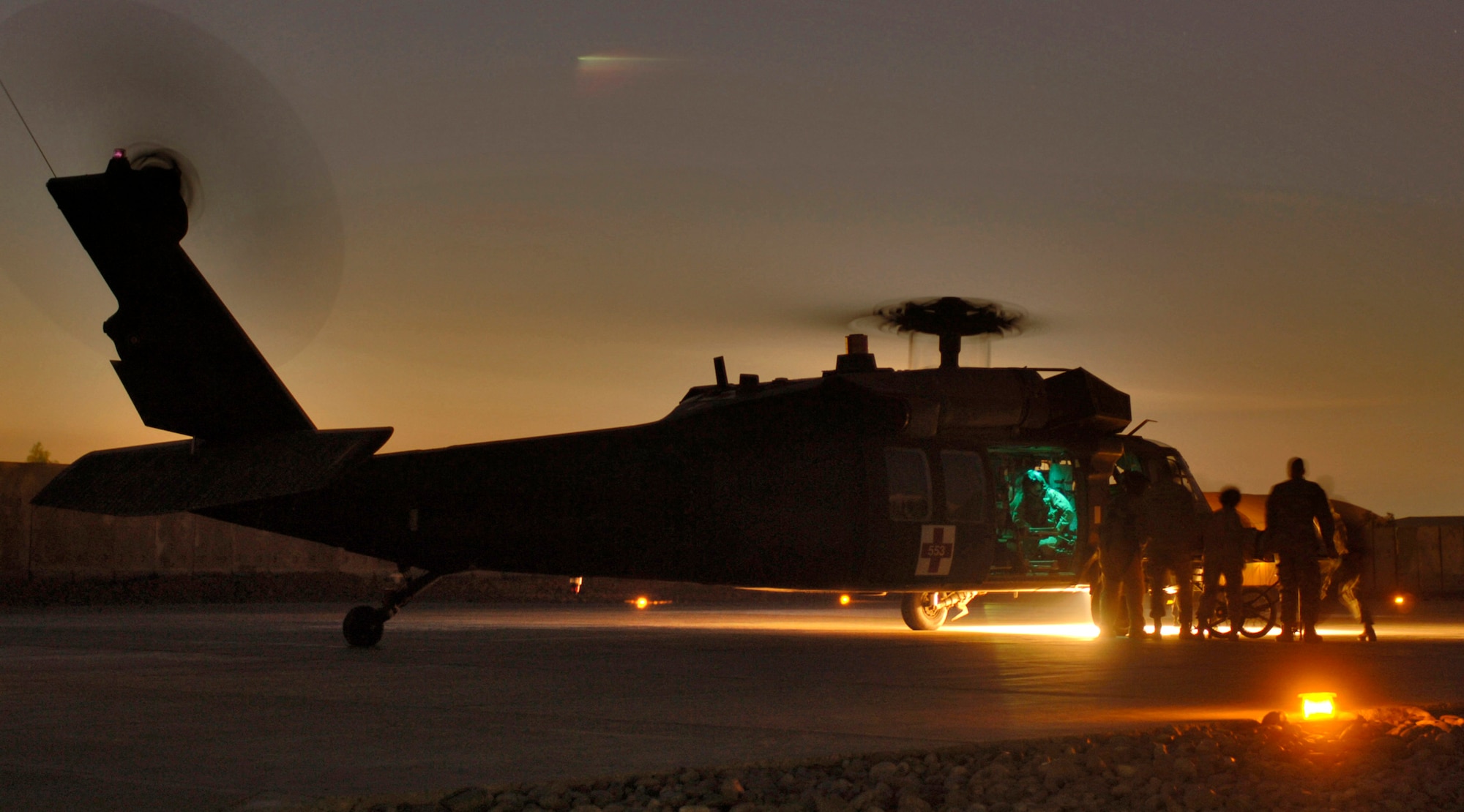 BALAD AIR BASE, Iraq (AFPN) -- An Army air evacuation Blackhawk Helicopter UH-60 is met by Air Force and Army medics at the Air Force Theater Hospital here Jan. 29. The hospital provides Level 1 trauma and specialized medical care throughout the Iraqi theater.  Some of their specialties include neurosurgery, orthopedics, oral maxillofacial and vascular medicine.(U.S. Air Force photo by Master Sgt. Lance Cheung)    
