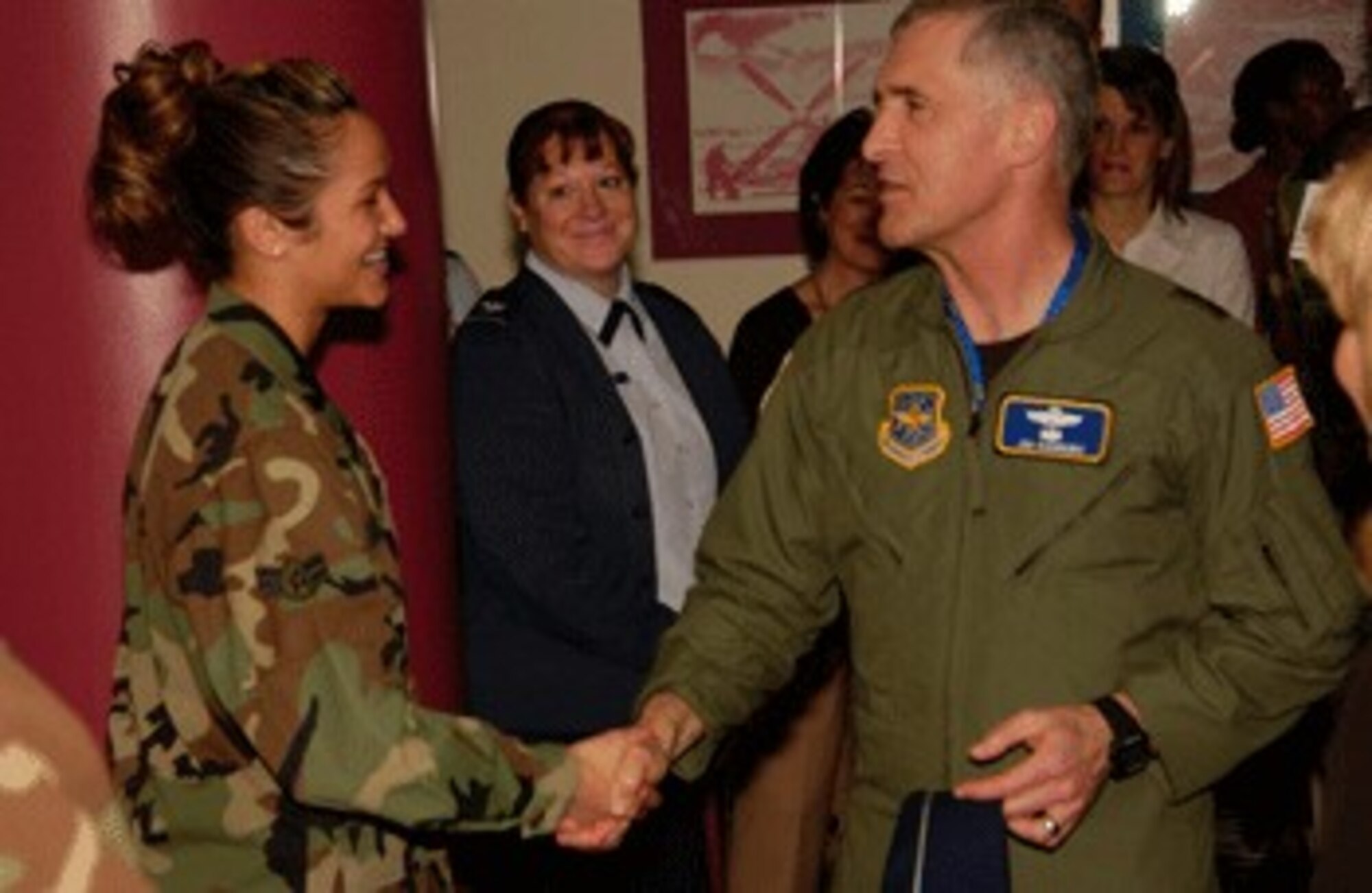 Airman 1st Class Jacklynn Levasseur, 60th Medical Diagnostics and Therapeutic Squadron, receives a coin from Maj. Gen. James A. Hawkins, 18th Air Force commander, Tuesday after returning from a short-notice deployment to Iraq. General Hawkins and his wife, Linda, met with Travis Airmen and community leaders during their one-day tour of the base.