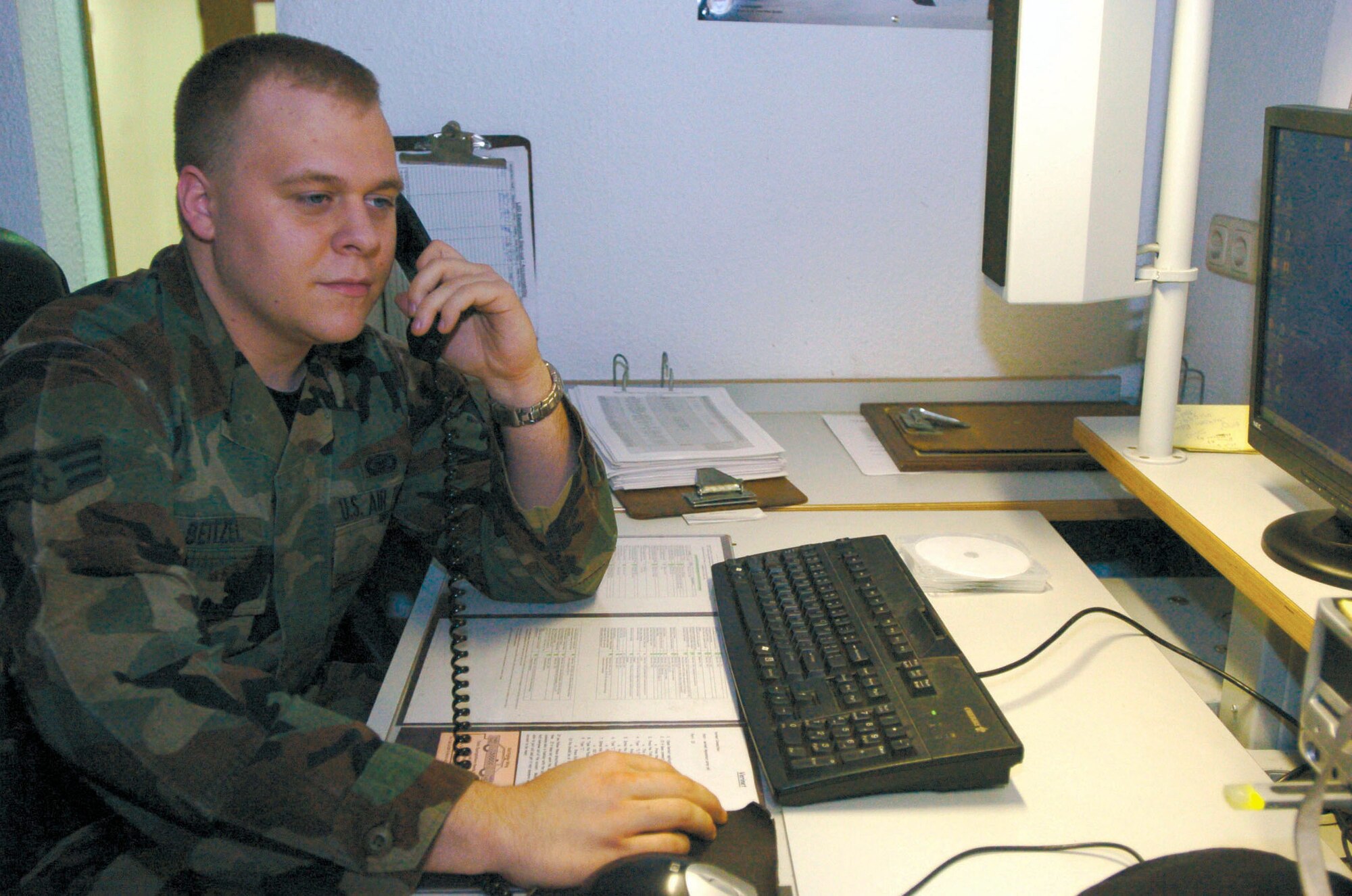 SPANGDAHLEM AIR BASE, Germany (AFPN) -- Senior Airman Tony Beitzel answers a law enforcement desk call during his shift Jan. 24. Airman Beitzel said the hardest part of his job is trying to get errands done during the day. He is a controller assigned to the 52nd Security Forces Squadron. (U.S. Air Force photo by Senior Airman Amaani Lyle)