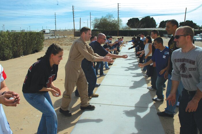 Sailors from the Branch Medical Clinic play a game called ?toss the egg? involving pairs of contestants who throw an egg back and fourth to each other while stepping back after each completed catch as part of the BMC?s 3rd Annual Super Bowl Tailgate  party Feb. 2 here.