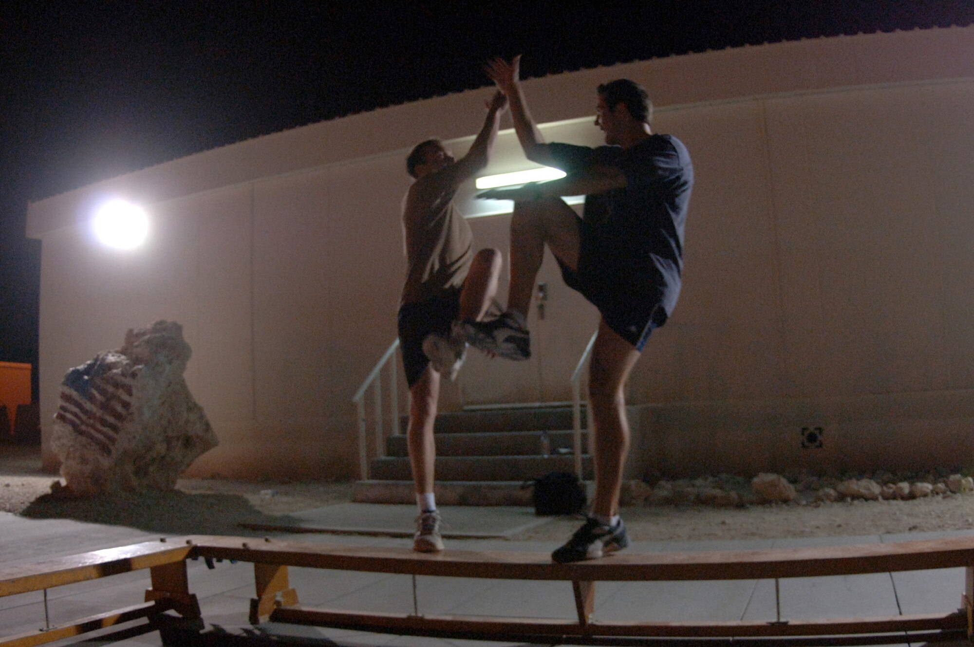 SOUTHWEST ASIA (AFPN) -- Two Royal Air Force Airmen give a "high five" while participating in "combat aerobics" here Feb. 2. The class is offered three nights a week and helps deployed airmen stay in shape.  (U.S. Air Force photo by Staff Sgt. Joshua Strang)