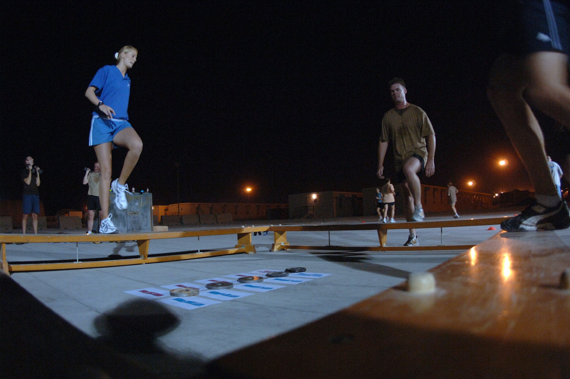 SOUTHWEST ASIA (AFPN) -- Royal Air Force Corporal Lyn McCartney leads American, English and Australian airmen in stretching exercises before a "combat aerobics" class here Feb. 2. The class is offered three nights a week and helps deployed airmen stay in shape. (U.S. Air Force photo by Staff Sgt. Joshua Strang)