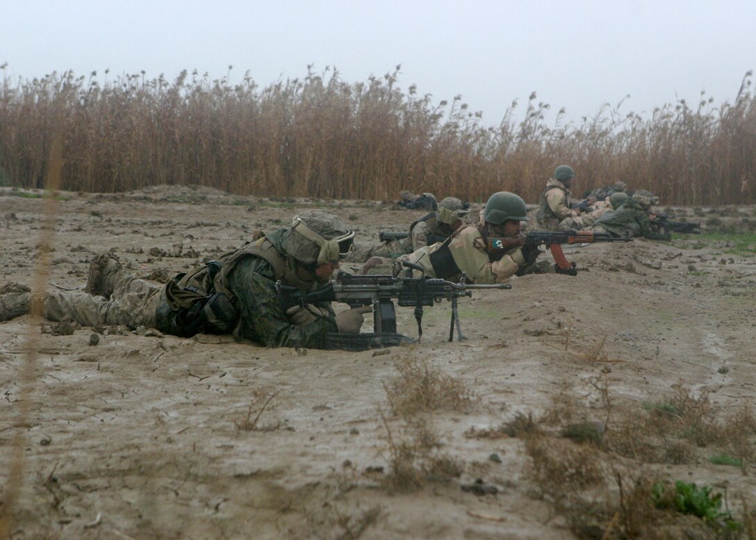 During Operation Smokewagon, Marines with Bravo Co., Battalion Landing Team, 1st Bn., 2nd Marines, conduct squad rushes with Iraqi soldiers during a firefight Feb. 3, 2006.  The 22nd MEU (SOC) is conducting counterinsurgency operations in Al Anbar province alongside an Iraqi infantry battalion, collectively under the tactical control of the 2nd Marine Division.