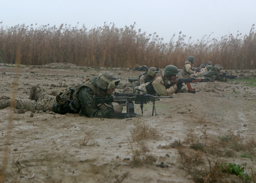 During Operation Smokewagon, Marines with Bravo Co., Battalion Landing Team, 1st Bn., 2nd Marines, conduct squad rushes with Iraqi soldiers during a firefight Feb. 3, 2006. The 22nd MEU (SOC) is conducting counterinsurgency operations in Al Anbar province alongside an Iraqi infantry battalion, collectively under the tactical control of the 2nd Marine Division.