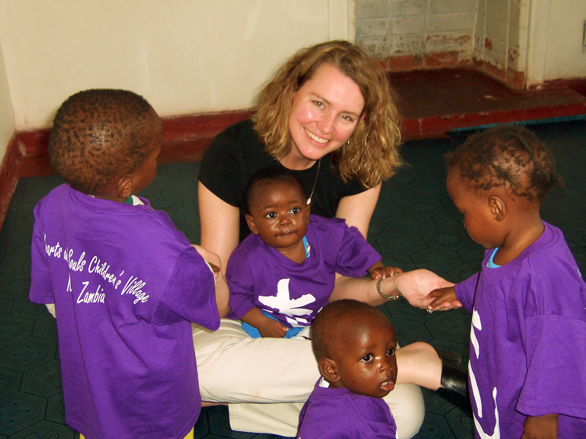 ZAMBIA (AFPN) -- Kim Milhoan plays with children in the first AIDS orphanage. She and her husband, Lt. Col. (Dr.) Kirk Milhoan, funded two facilities here with charitable donations through non-profit organizations. (U.S. Air Force photo by Col. (Dr.) Kirk Milhoan) 
