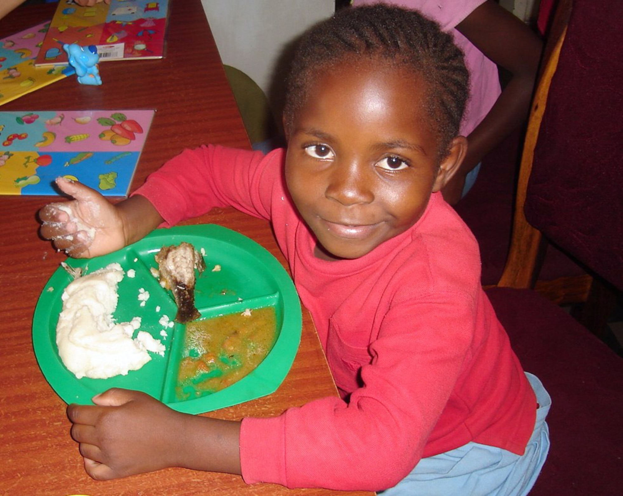 ZAMBIA (AFPN) -- Six-year-old Doris eats a meal at the AIDS orphanage in Zambia. Doris' mother died of AIDS and her father regularly abused her before she came to stay at the facility. (U.S. Air Force photo by Lt. Col. (Dr.) Kirk Milhoan) 

