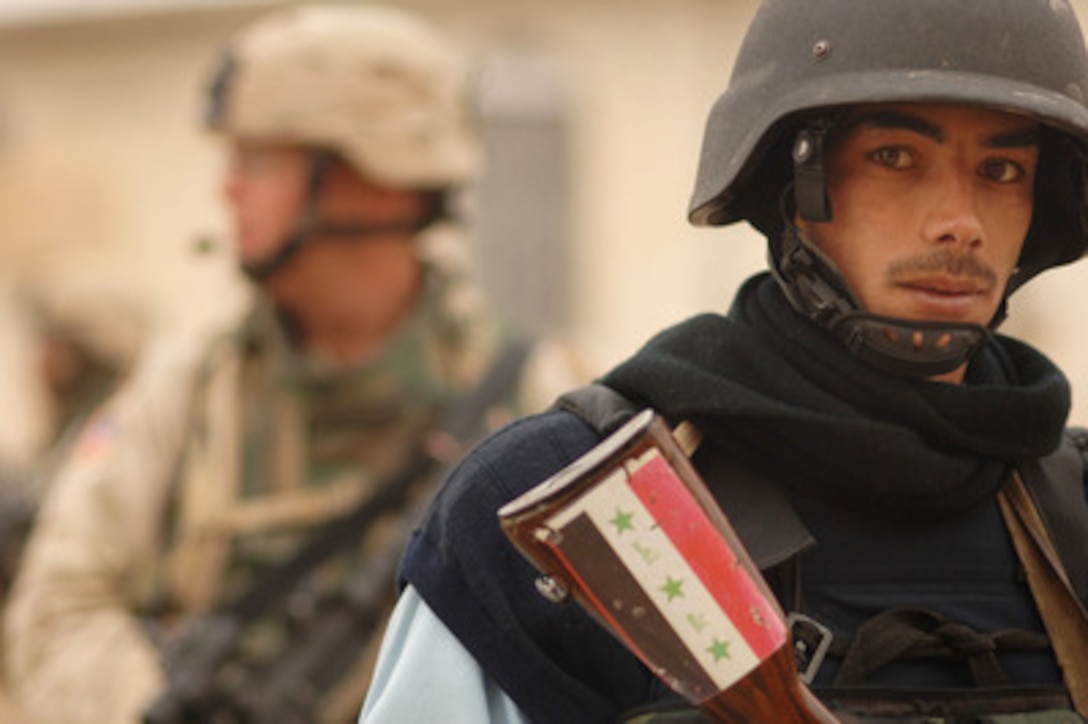 A member of the Iraqi Police and a U.S. Army soldier with the 3rd Armored Cavalry Regiment conduct a joint combat patrol in Tall Afar, Iraq, on Feb. 2, 2006. 