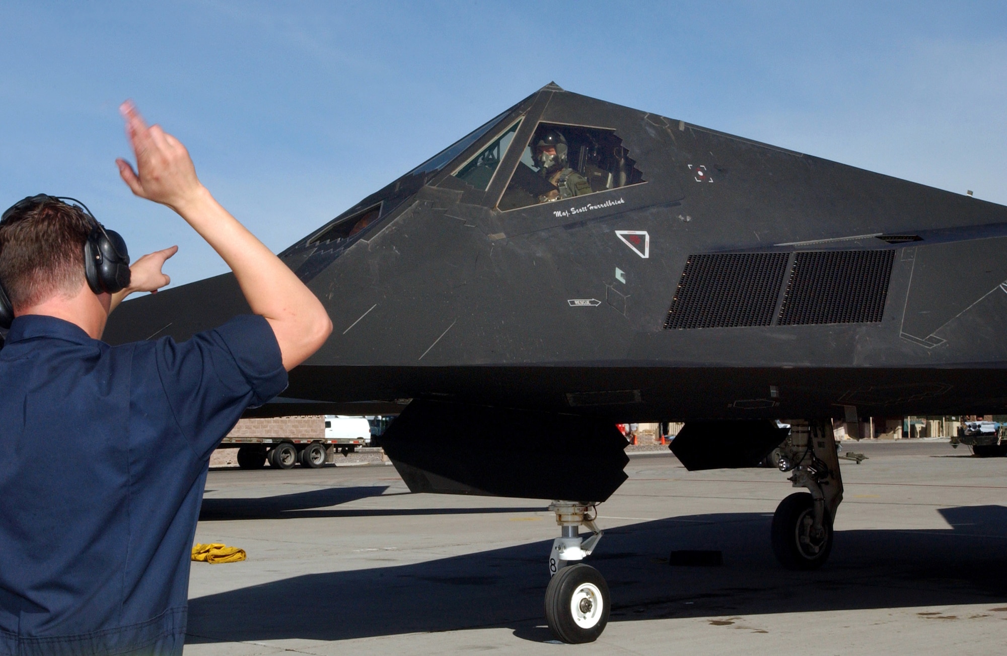 NELLIS AIR FORCE BASE, Nev. (AFPN) -- Senior Airman Colin Webb marshalls out an F-117A Nighthawk, piloted by Capt. Erik Jacobson, during Red Flag 06-1, here Jan. 21 to Feb. 18. Red Flag is an exercise that tests aircrews' warfighting skills. Flights involve more than 100 aircraft, including B-52 Stratofortresses and F-16 Fighting Falcons. The aircraft are flying missions day and night to the nearby Nevada Test and Training Range where they simulate an air war. Along with the Air Force, units from the Army, Navy, NATO and several allied countries are participating. Captain Jacobson is an F-117A Nighthawk pilot with the 49th Fighter Squadron at Holloman Air Force Base, N.M. Airman Webb is a crew chief with the 49th Aircraft Maintenance Squadron. (U.S. Air Force photo by Staff Sgt. Kenny Kennemer)
