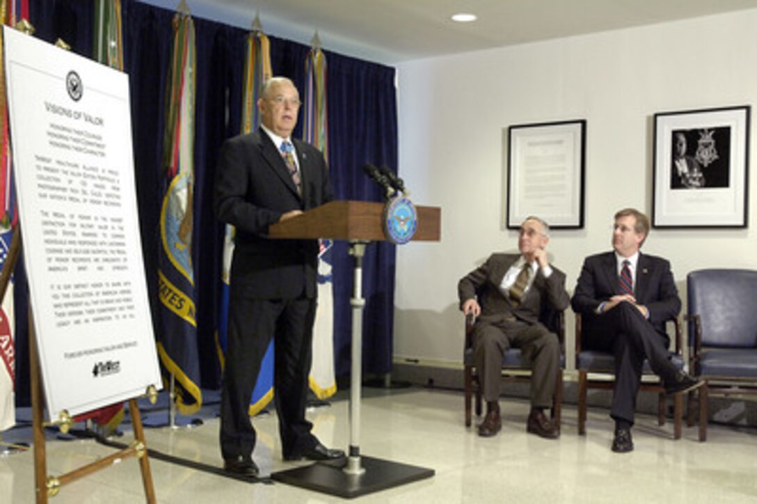 President of the Congressional Medal of Honor Society Gary Littrell speaks during a ceremony opening the Visions of Valor display in the Pentagon on Feb. 3, 2006. Tri-West Healthcare Alliance commissioned two sets of the photographs by Nick DelCalzo that depict 116 of the recipients of the Congressional Medal of Honor. Deputy Secretary of Defense Gordon England (center) hosted the ceremony and was joined by Tri-West President and CEO David McIntyre. One set was donated for permanent display in the Pentagon and the other will comprise a traveling exhibit to be shown nationally. 