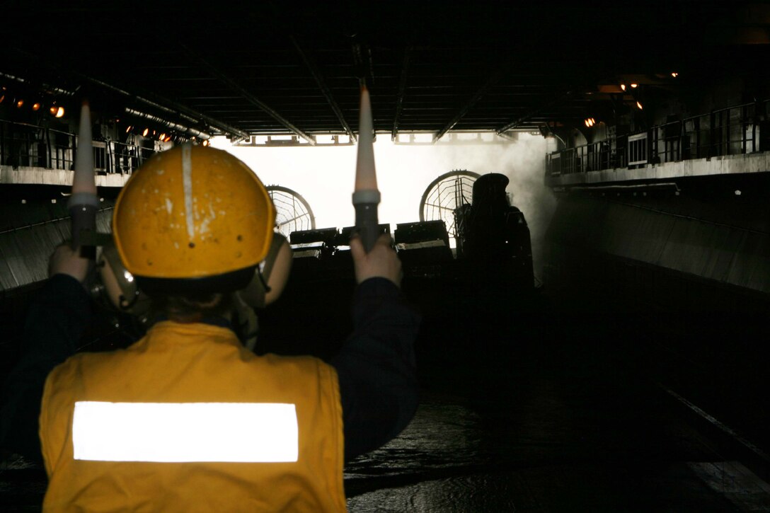 A Landing Craft Air Cushioned is guided into the well deck of the USS Iwo Jima during driver?s improvement training held during Expeditionary Strike Group/MEU Integration Training Feb. 8.  The training sought to hone Marine?s skills in shipboard driving, driver safety, and LCAC operations.