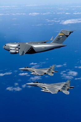 HICKAM AIR FORCE BASE, Hawaii (AFPN) -- F-15B Eagles from the 199th Fighter Squadron, 154th Wing, Hawaii Air National Guard escort the first Hawaii-based C-17 Globemaster III to its home. Hickam is the first base outside the continental U.S. to permanently host the C-17. By the end of the year the base will be home to eight C-17s. The 15th Airlift Wing and the 154th Wing will jointly operate and maintain the aircraft. (U.S. Air Force photo by Tech. Sgt. Shane A. Cuomo)