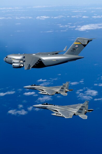 HICKAM AIR FORCE BASE, Hawaii (AFPN) -- F-15B Eagles from the 199th Fighter Squadron, 154th Wing, Hawaii Air National Guard escort the first Hawaii-based C-17 Globemaster III to its home. Hickam is the first base outside the continental U.S. to permanently host the C-17. By the end of the year the base will be home to eight C-17s. The 15th Airlift Wing and the 154th Wing will jointly operate and maintain the aircraft. (U.S. Air Force photo by Tech. Sgt. Shane A. Cuomo)