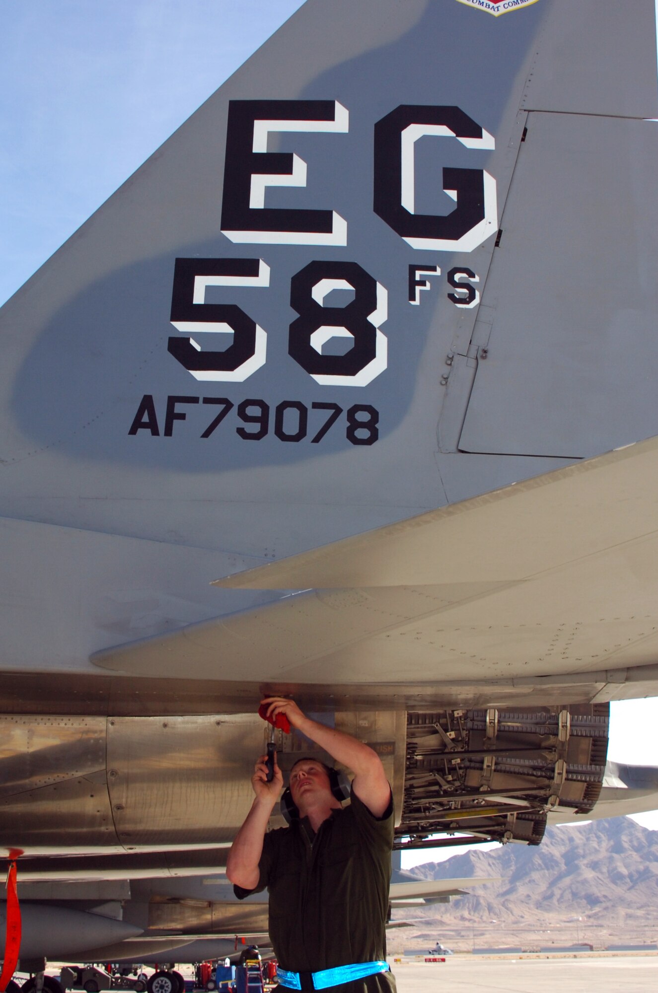 NELLIS AIR FORCE BASE, Nev. (AFPN) -- Senior Airman Jeff Musselman tightens screws on an F-15 Eagle Feb. 6 during Red Flag 06-1 here. More than 130 aircraft and 2,500 personnel are supporting the simulated air war over the Nellis Test and Training Range. Airman Musselman is a crew chief with the 58th Aircraft Maintenance Unit at Eglin Air Force Base, Fla. (U.S. Air Force photo by 1st Lt. David Tomiyama)