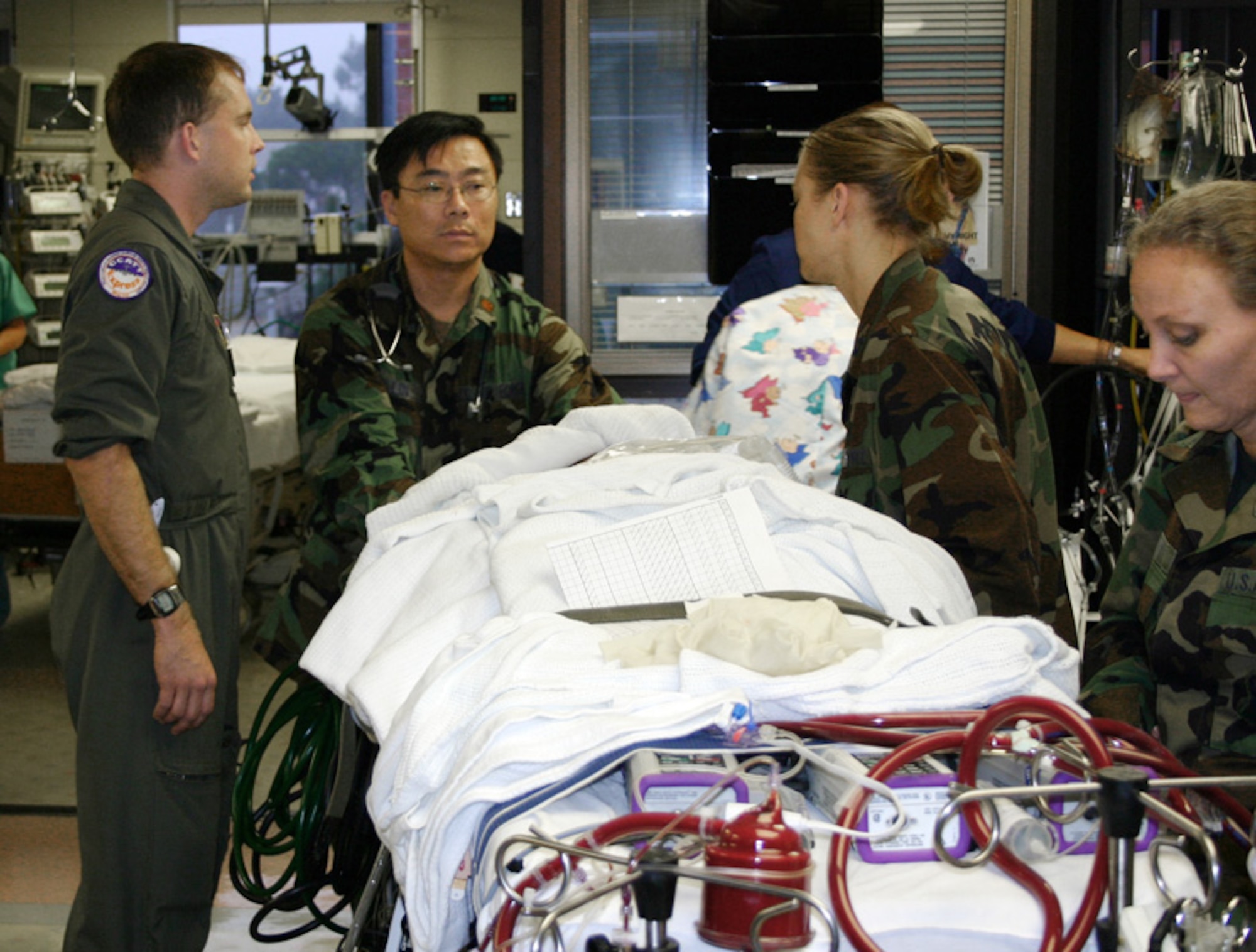 LOS ANGELES (AFPN) -- Maj. (Dr.) John Lin guides the ECMO machine holding 7-year-old Meaghan Ababa into the pediatric intensive care unit at the Children's Hospital in Los Angeles with the help of team members (left) Staff Sgt. Matthew Falat, neonatal respiratory care specialist, and pediatric clinical nurses, Capts. Andrea Christ and Karen Larry. Major Lin is a pediatric intensivist at Wilford Hall Medical Center, Lackland Air Force Base, Texas. (U.S. Air Force photo by Master Sgt. Kimberly Spencer) 