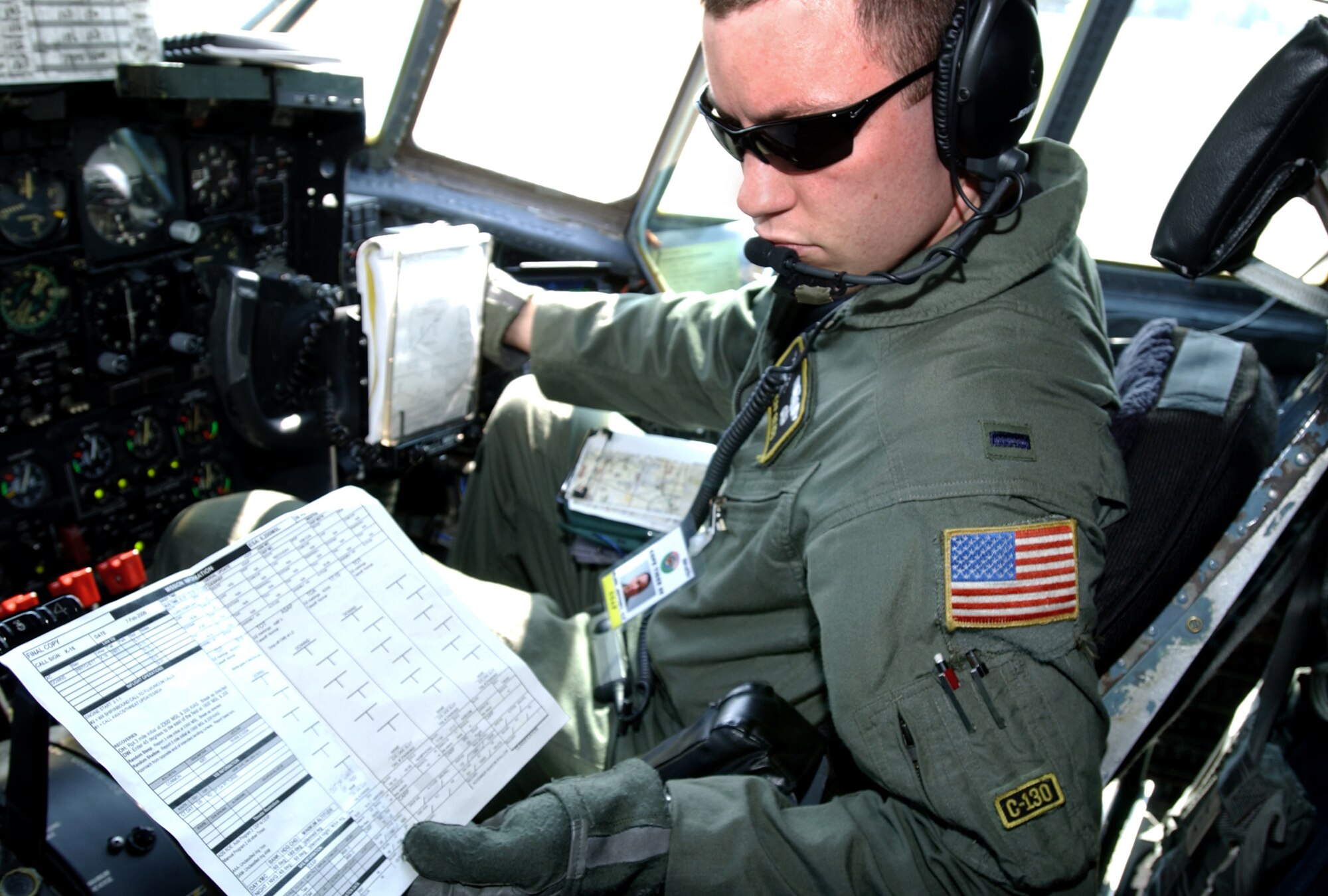 KORAT ROYAL AIR FORCE BASE, Thailand (AFPN) -- First Lt. Jeff Bliss reads information about a Cope Tiger '06 airlift mission inside the cockpit of a C-130 Hercules here Feb. 7.  Lieutenant Bliss is one of 300 U.S. military members and 1,000 military members from Thailand and Singapore who are participating in the exercise, headquartered 110 miles northeast of Bangkok. Officials say Cope Tiger provides air-to-air, air-to-ground and large force employment training for crews in a multi-national environment while expanding the capabilities and readiness of U.S. and allied forces. Cope Tiger '06 is scheduled to end Feb. 18. Lieutenant Bliss is a C-130 pilot with the 36th Airlift Squadron at Yokota Air Base, Japan. (U.S. Air Force photo by Tech. Sgt. Keith Brown) 