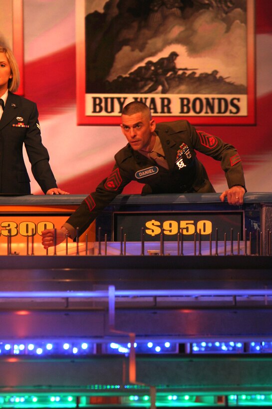 Staff Sgt. Daniel L. Norton, information assurance chief with 9th Communications Battalion, 1st Marine Division, reaches down and gives the wheel a spin during a taping of "Wheel of Fortune" at Sony Entertainment Studios in Los Angeles Feb. 8. The 37-year-old from Mt. Arlington, N.J., was among 15 servicemembers who appeared on the popular game show when it hosted "Wheel Salutes the Armed Forces," which is scheduled to air the week of April 3.