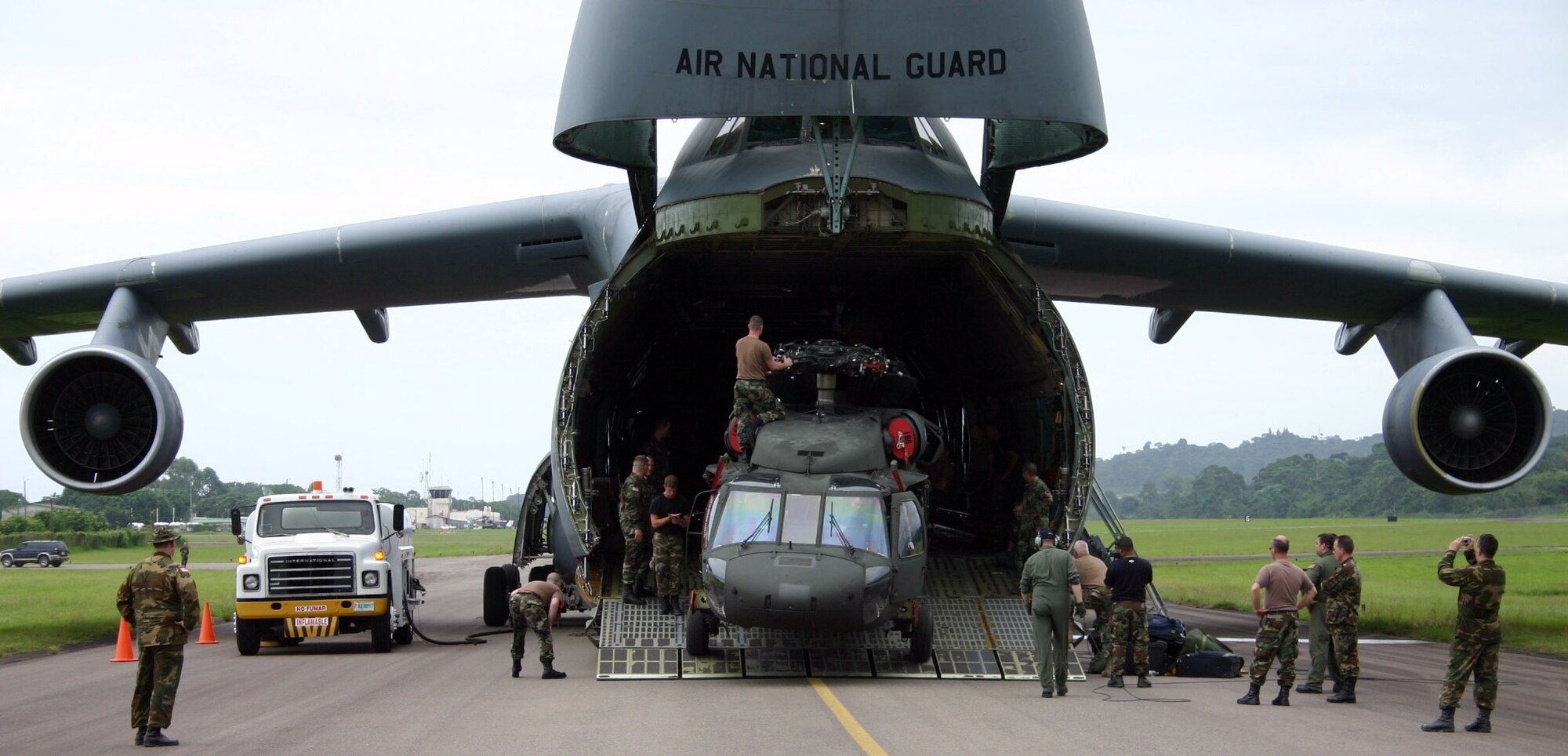 LA CEIBA, Honduras (AFPN) -- Crew members move a UH-60 Black Hawk off of a C-5 Galaxy in La Ceiba, Honduras. The C-5, from the 105th Airlift Wing, New York Air National Guard, delivered three Black Hawks and a Humvee for the "New Horizons 2006 -- Honduras" joint training exercise. The Black Hawks, deployed here from the New York Army National Guard's 3-142 Aviation Battalion, will provide transport and emergency evacuation support for New Horizons. (U.S. Air Force photo by Capt. Mike Chillstrom)