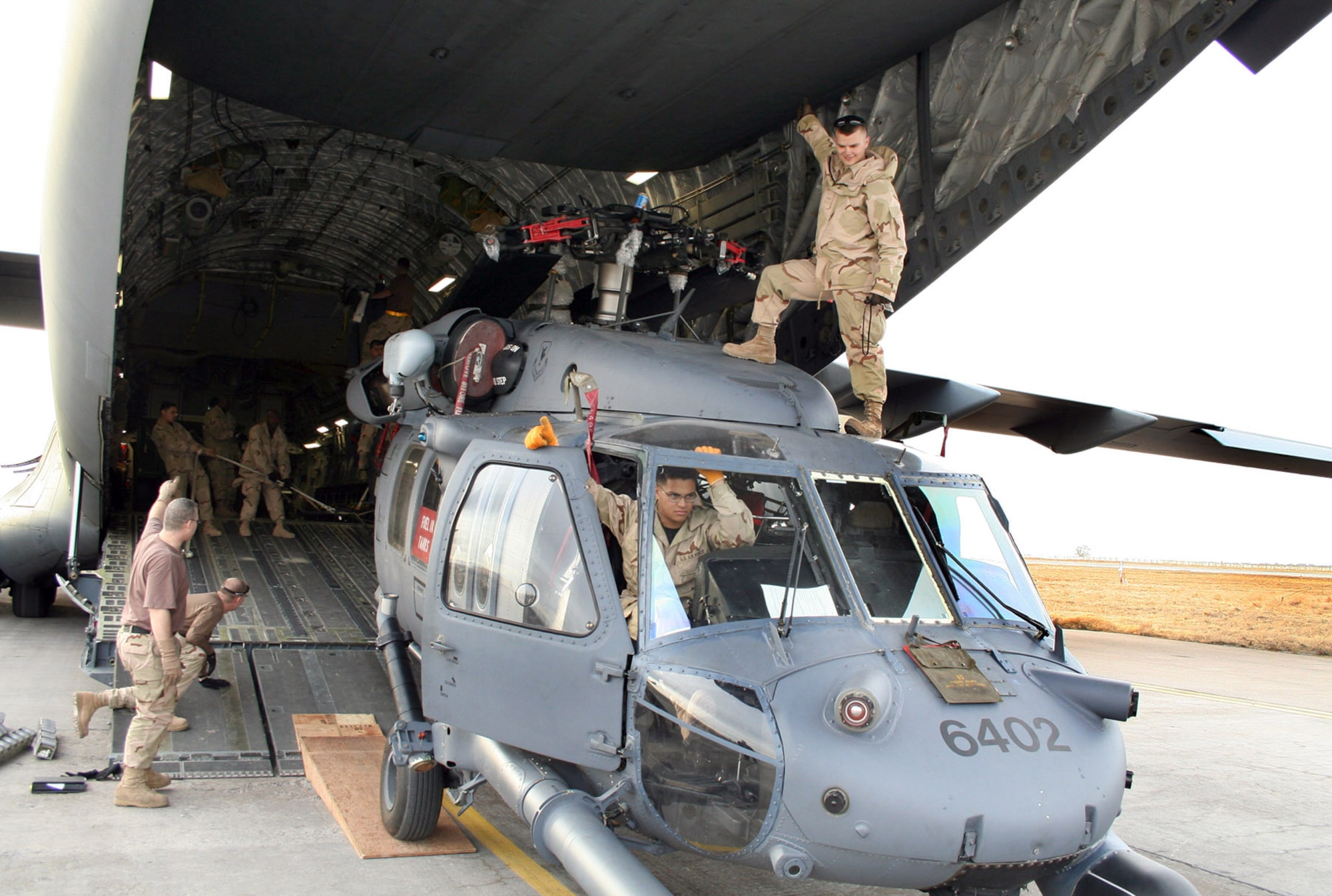 MANAS AIR BASE, Kyrgyzstan (AFPN) -- 376th Air Expeditionary Wing aerial porters work with maintainers to load a UH-60L Blackhawk helicopter into a C-17 Globemaster III supporting Operation Enduring Freedom. The maintainers and helicopter are deployed from the 33rd Rescue Squadron, Kadena Air Base, Japan. (U.S. Air Force photo by Staff Sgt. Lara Gale)