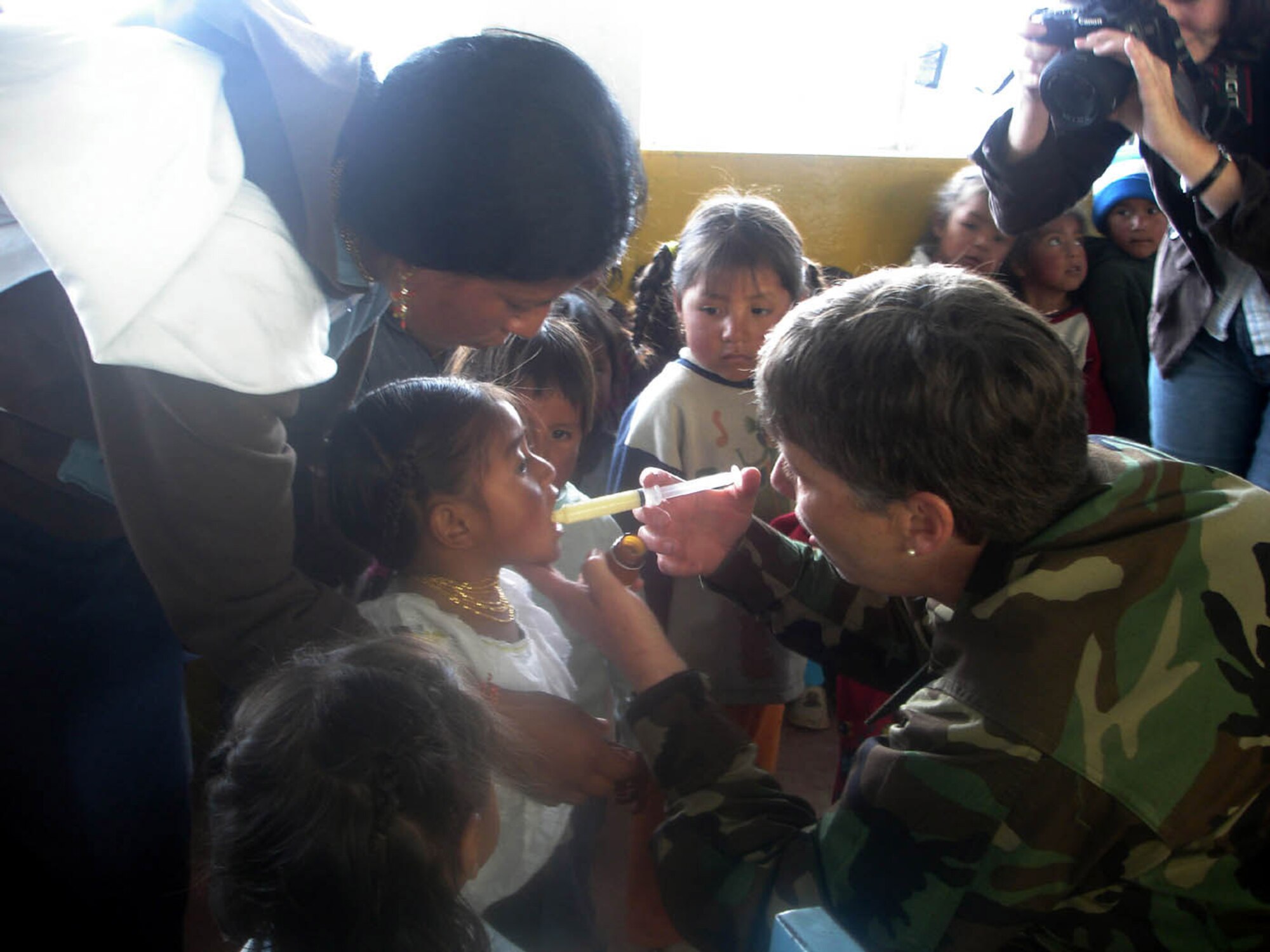 OTAVALO, Ecuador (AFPN) -- Lt. Col. (Dr.) Karen Kinne gives a child anti-parasitic medicine with help from the girl's mother. The anti-parasitic medicine treats gastrointestinal infections that are prevalent in the region. Colonel Kinne is the medical readiness exercise commander for the Air Force team here, and is assigned to the 21st Medical Group at Peterson Air Force Base, Colo. (U.S. Air Force photo by Capt. Kim Melchor) 