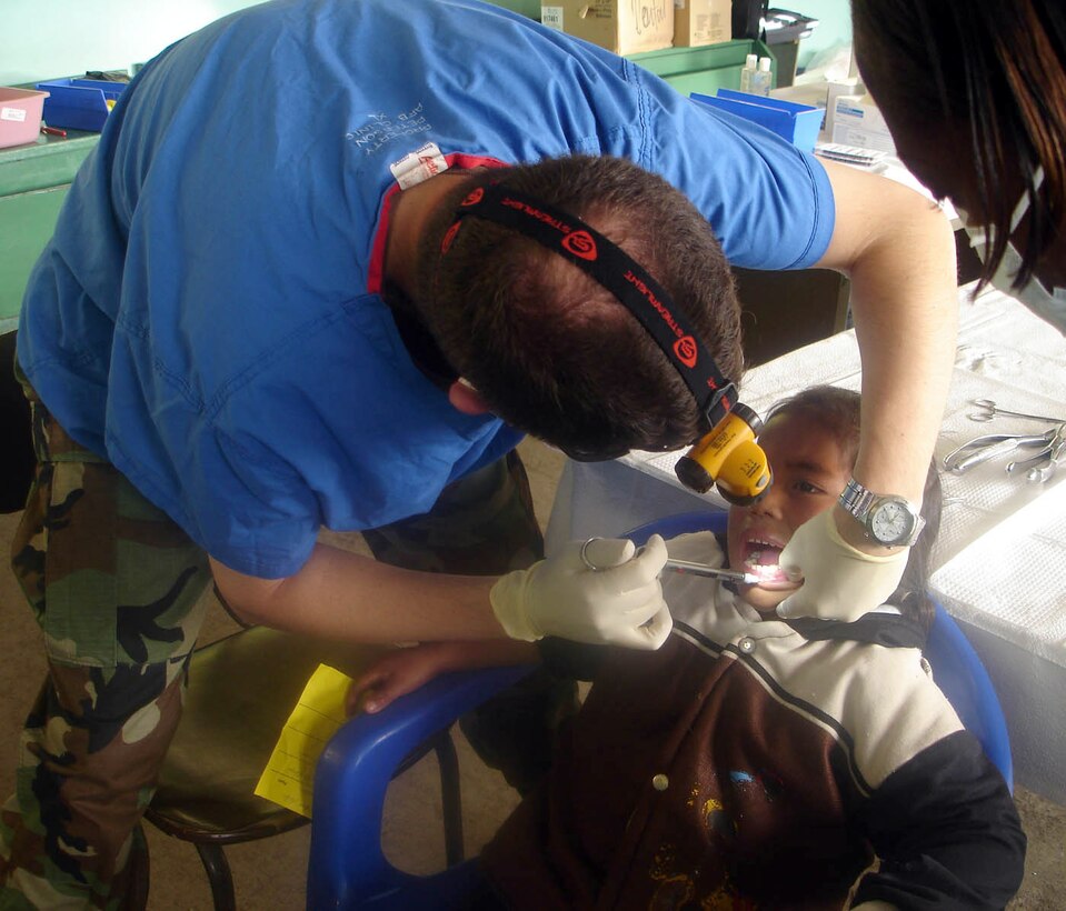 OTAVALO, Ecuador (AFPN) -- Capt. (Dr.) Roger Miller numbs an Ecuadorian girl's mouth before pulling a tooth. Air Force teams from the U.S. and Ecuador pulled more than 2,000 teeth during the 10-day medical readiness exercise. Captain Miller is a dentist from the 21st Medical Group at Peterson Air Force Base, Colo. (U.S. Air Force photo by Capt. Kim Melchor) 